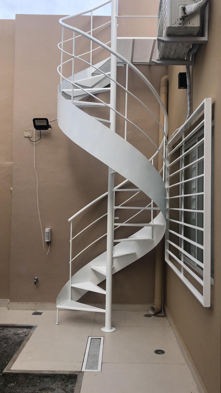 Escalera caracol blanca exterior en patio