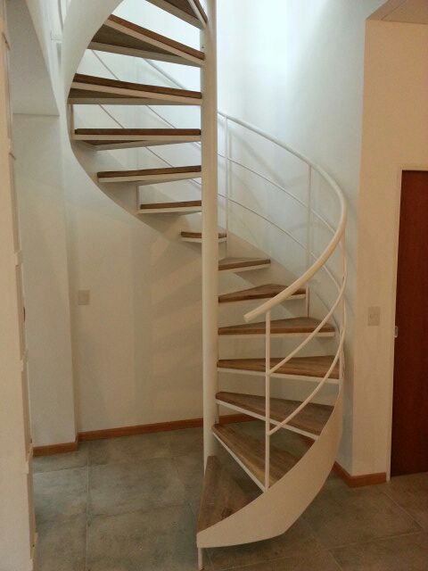 Escalera caracol blanca interior con peldaños de madera