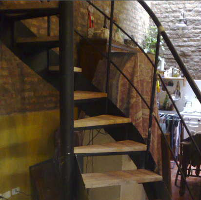 Escalera caracol rústica interior con peldaños de madera clara