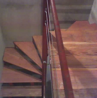 Escalera compensada interior con peldaños de madera y baranda de cable