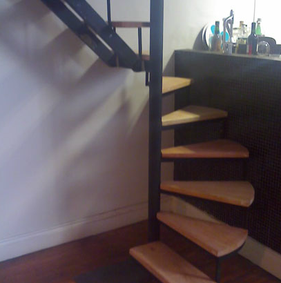 Escalera caracol negra interior de pequeñas dimensiones