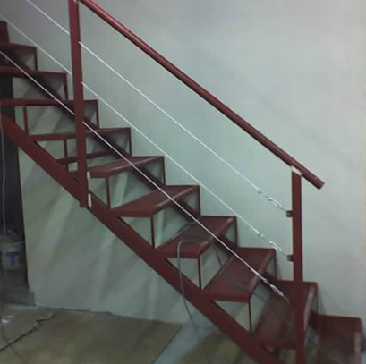 Escalera recta color bordó interior con baranda de cable, en obra