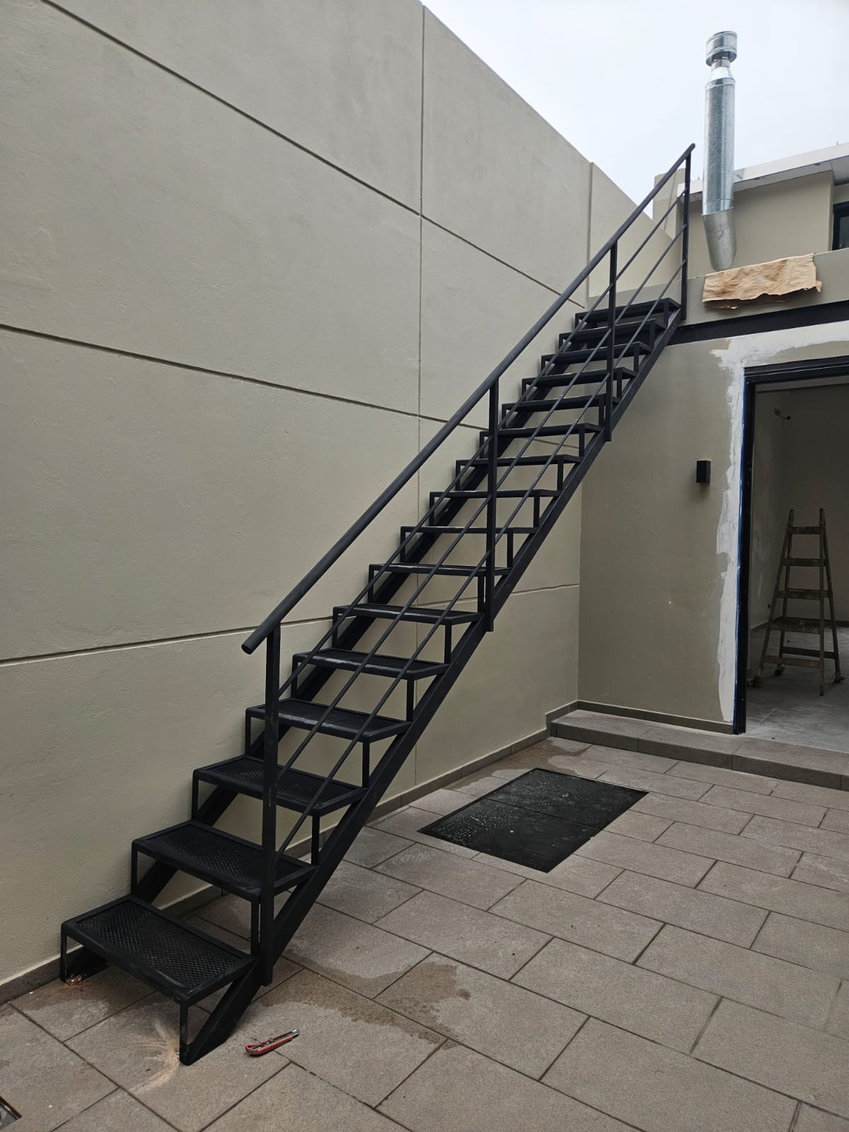 Escalera recta exterior con peldaños de rejilla metálica