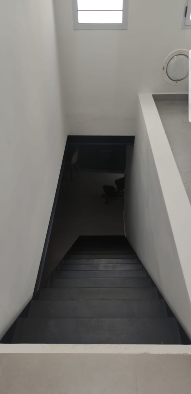 Escalera recta interior minimalista en tonos oscuros