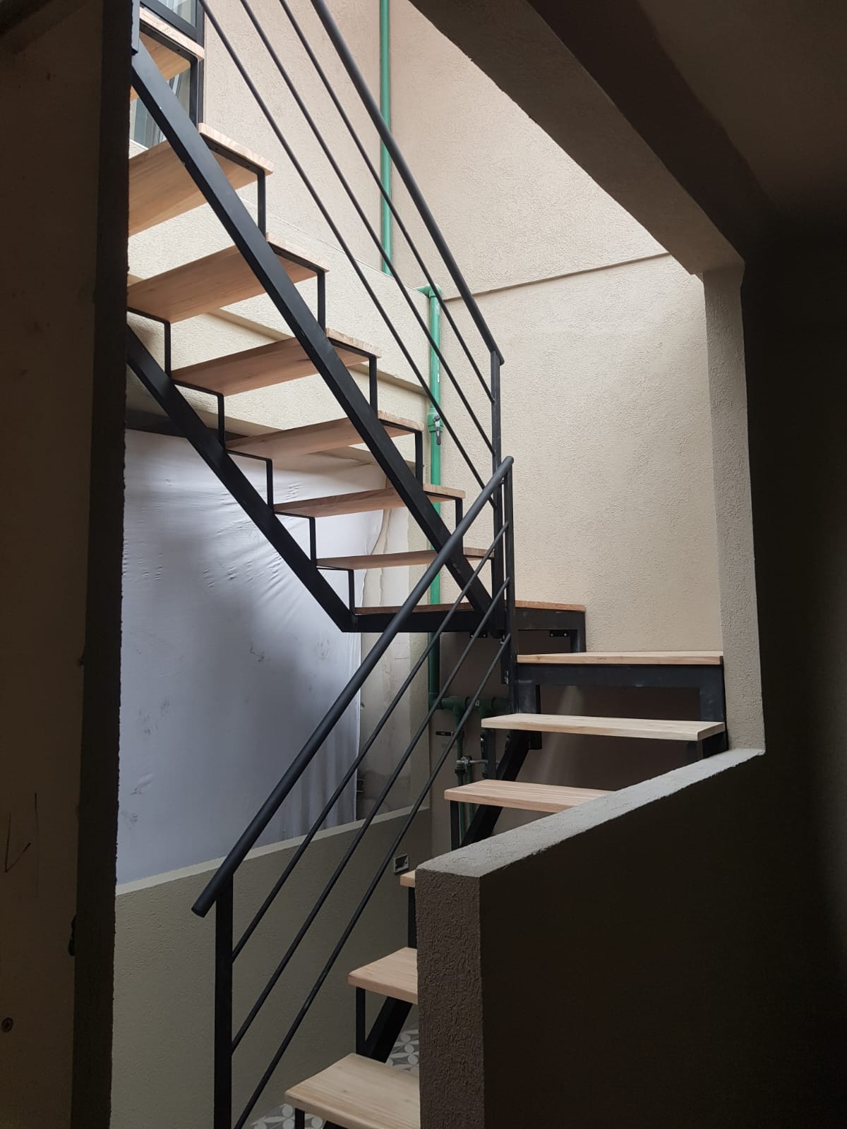 Escalera recta de hierro con peldaños de madera natural